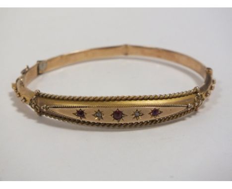 AN EDWARDIAN STYLE HALLMARKED 9 CARAT GOLD BANGLE SET WITH RUBIES 
