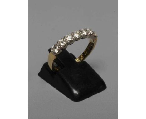 A SEVEN STONE DIAMOND HALF HOOP ETERNITY RING, the brilliant cut stones claw set to a plain 18ct gold shank, London 1983, siz