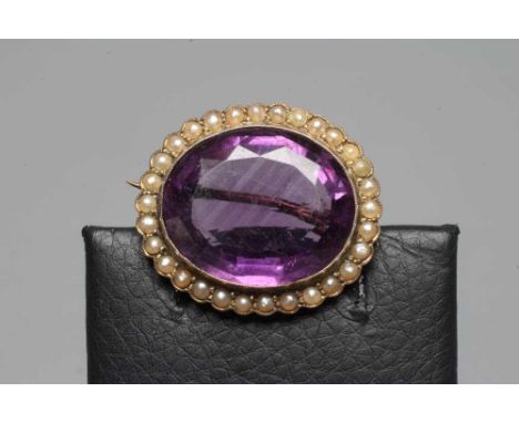 A VICTORIAN AMETHYST BROOCH, the oval facet cut stone collet set to a border of seed pearls, with applied plaque stamped 9ct 