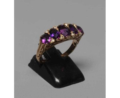 AN AMETHYST AND DIAMOND DRESS RING, the five oval facet cut amethysts claw set with diamond points between to carved shoulder
