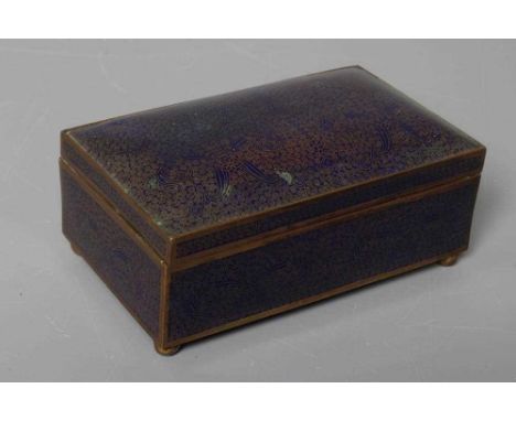 A CHINESE CLOISONNE ENAMEL CIGARETTE BOX of plain oblong form raised upon four ball feet, all-over decorated with scrolls and