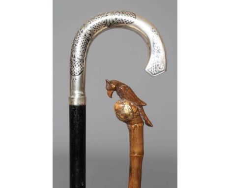 A 15CT GOLD MOUNTED BAMBOO STYLE WALKING CANE with exotic bird handle, 37" long, together with an ebonised walking cane with 