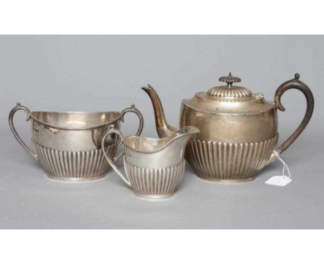 AN EDWARDIAN THREE PIECE TEA SERVICE by John Round &amp; Son Ltd., Sheffield 1911, of semi-fluted oval form, comprising teapo
