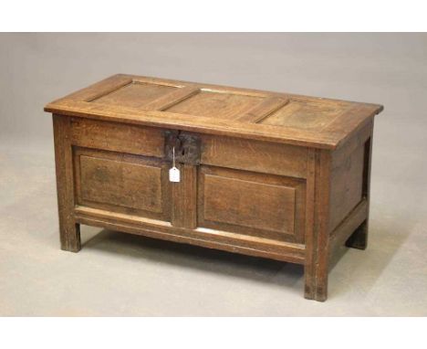 A SMALL JOINED OAK PANELLED COFFER, first half 18th century, the triple panel hinged lid with moulded front edge opening to i