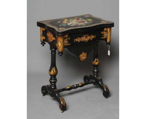 A VICTORIAN PAPIER MACHE WORK/GAMES TABLE, third quarter 19th century, the oblong serpentine top painted with a floral bouque