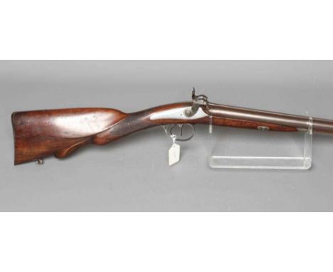 A PERCUSSION DOUBLE BARELLED RIFLE with 34 5/8" damascus barrels, lion head cocks, wood stock carved with cheek piece and flo