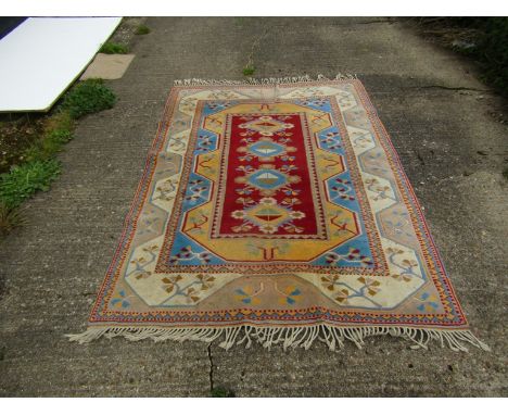 A hand woven Caucus rug with light blue colouring and tasselled ends, 230cm x 163cm            