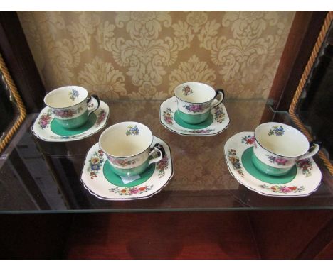 Seven Wedgwood coffee cups and saucers, green and cream with floral design