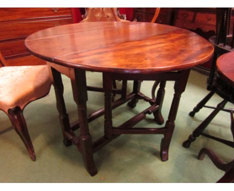 Circa 1760 an oak and elm circular drop leaf gate-leg table on turned legs and outswept feet with end drawer, 89cm diameter x
