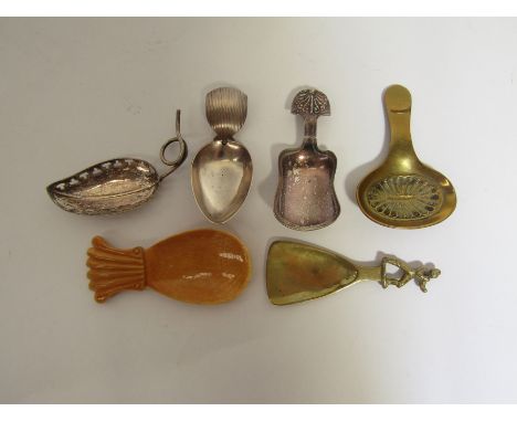 A group of six caddy spoons including examples of Old Sheffield Plate, 'elongated leaf' shape, brass shell, a brass figural s