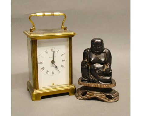 A Brass Cased Carriage Clock together with a Japanese Model of Buddha with hardwood stand 