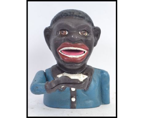 A vintage style cast iron hand painted money box in the form of a ' Jolly Negro ' with moving hand and facial features. 
