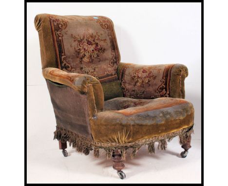 A Victorian tapestry upholstered chesterfield armchair in the manner of Howard & Sons. Raised on turned legs with fabulous ta