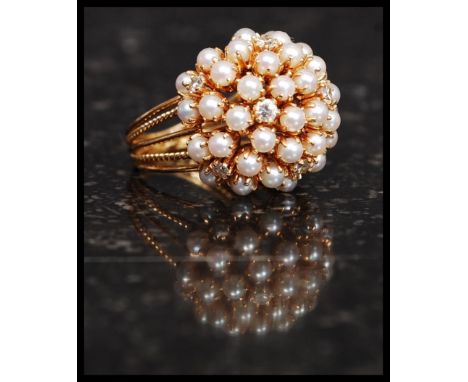 A stunning 18 / 22ct gold, diamond and seed pearl cluster ring. The split shank ring adorned with seed pearls being intersper