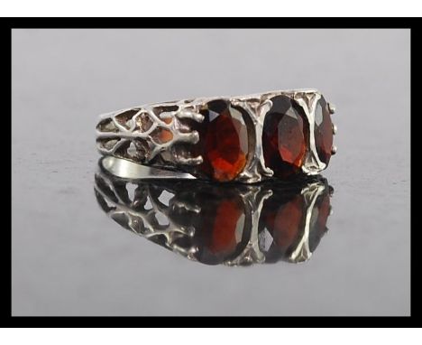 A silver 925 and ruby garnet stone ladies ring. The 3 large ruby garnets raised on a gypsy setting. Total weight 2.5g / Size 