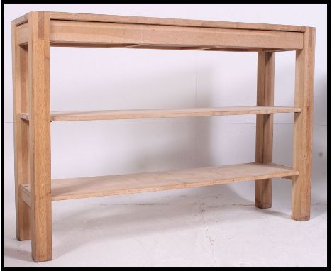 A good quality solid oak console table in the form of a workbench. Solid oak raised on square column supports with central sh