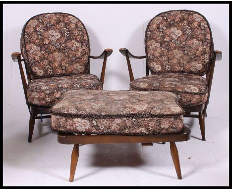 A pair of 1970's retro Ercol beech and elm Windsor pattern armchairs. Raised on stub turned legs with stretchers, shaped arms