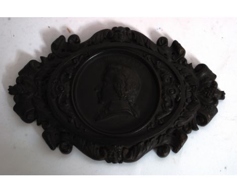 A rare and unusual large 19th century bois durci plaque of WA Mozart. The heavily cast surround adorned with leaves, pine con