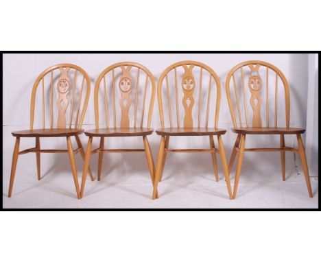 A set of four contemporary light elm seat and beech wheelback chairs, each chair having an Ercol button to the underside. H90
