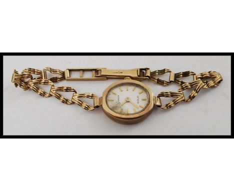 A 9ct gold / 375 marked ladies Geneve dress watch. Complete on 9ct chain with decorative watch with baton numerals. Total wei