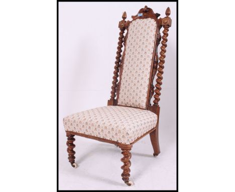 A Victorian 19th walnut barley twist nursing chair being raised on barley twist supports with white ceramic castors upholster