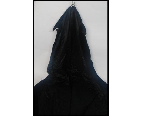 An retro full length 1970's black velvet cloak, having a fully lined interior