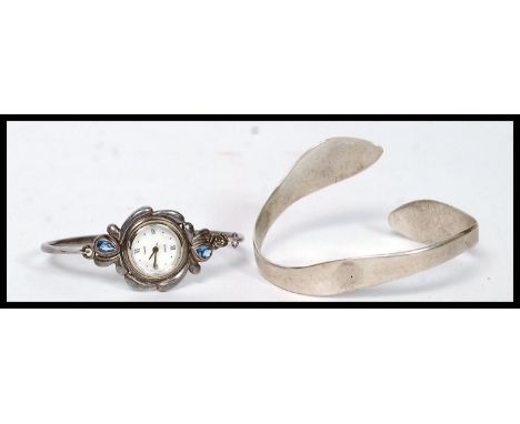 A silver 925 contemporary bangle bracelet together with a silver bracelet with inset roma watch. Total weight 51.5g