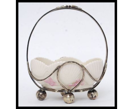 A Belleek ceramic dish, held within a white metal basket surround, makers marks to base. H16cm