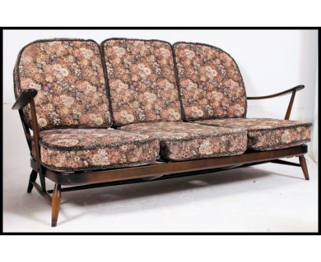 A 1970's retro Ercol beech and elm Windsor pattern 3 seat sofa settee couch. Raised on stub turned legs with stretchers, shap