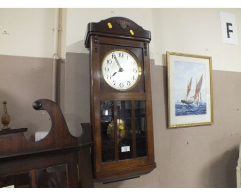 AN EDWARDIAN OAK GLAZED WALL CLOCK