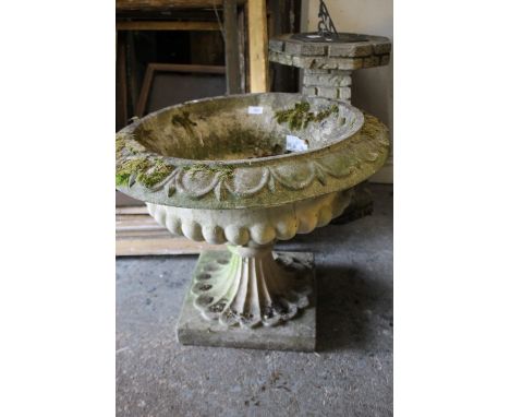 A CIRCULAR GARDEN PLANTER ON A BASE