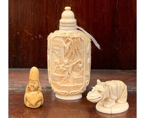 A 19th century Chinese carved ivory snuff bottle, with kylins carved to the sides and court scenes to the centre; together wi