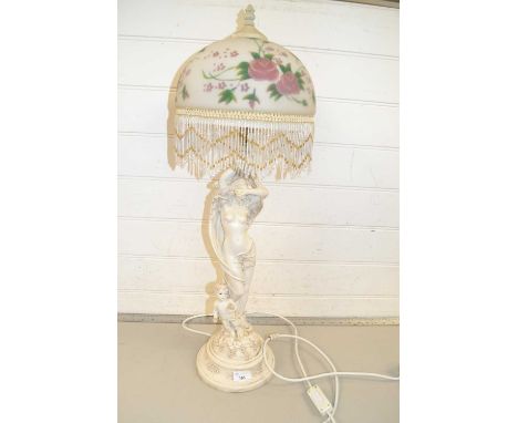 A modern figural table lamp with floral glass shade