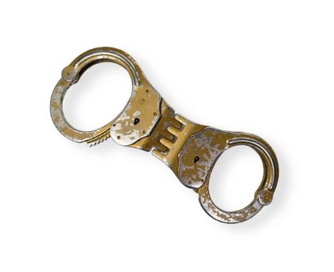 A pair of metal handcuffs (approx 22cm) likely screen used in Judge Dredd (1995). Provenance: the vendor attended a memorabil