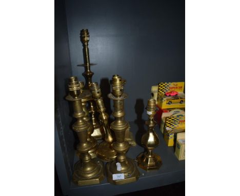 A good selection of early 20th century and later brass lamp bases including converted candlesticks and a classical column.