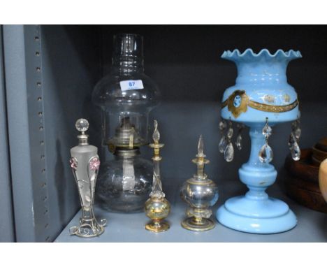 Three art glass scent or perfume bottles with a blue milk glass lustre AF and an oil lamp.