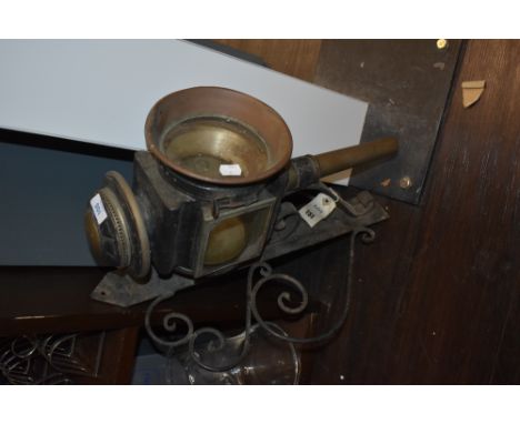 An early 20th century car or carriage lamp with mountable wall bracket.