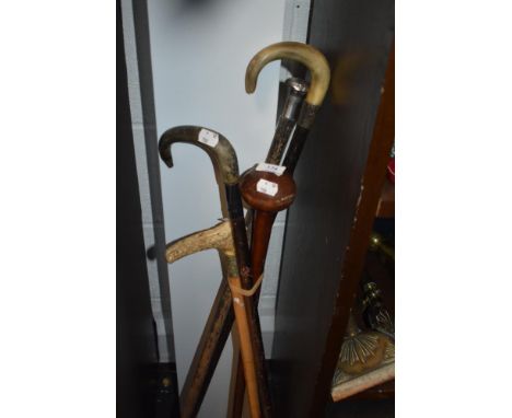 A HM silver cuffed walking stick horn handle a riding crop and a hard wood club.