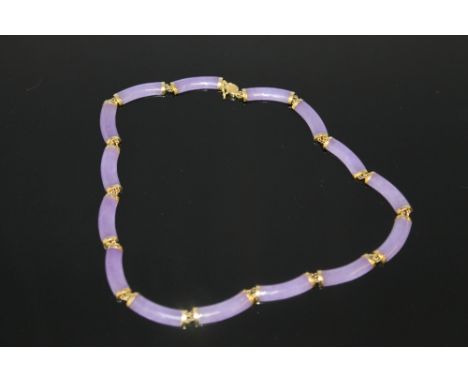 A DYED PURPLE JADE FIFTEEN SECTION NECKLACE, each capped with a 14ct gold end, L 16"
For shipping price on this lot please vi