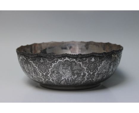 A PERSIAN STYLE WHITE METAL BOWL, the outside decorated with panels of figures in various scenes including hunting, processio