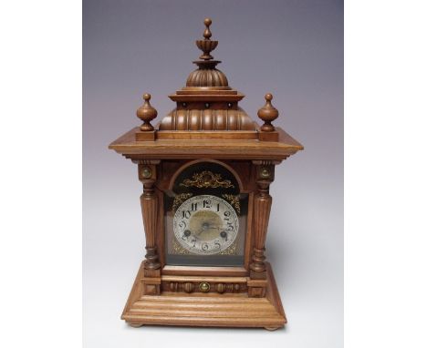 A GERMAN WALNUT MANTEL CLOCK WITH HAC MOVEMENT, architectural style case raised on bun feet, striking on a coil, paper trade 