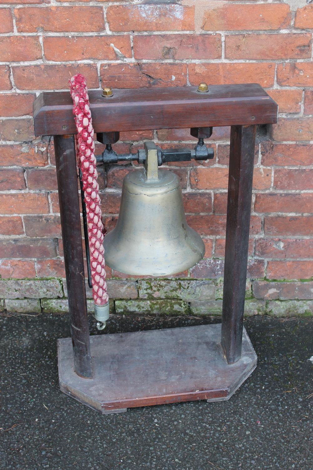 A LARGE CAST SHIPS BELL ON A WOODEN STAND, with striker, H 32 cm (Bell