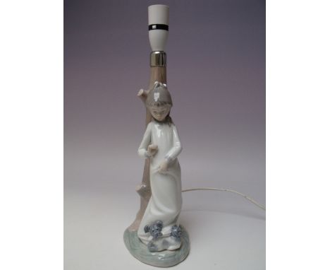 A NAO BY LLADRO PORCELAIN FIGURAL LAMP BASE, modelled in the form of a tree trunk, a young girl leaning against it with a dog