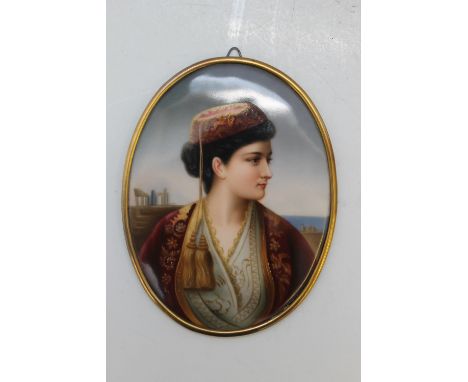 A 'BERLIN' STYLE OVAL PORCELAIN PLAQUE, depicting a half length portrait of a lady, dressed in traditional Greek costume, her