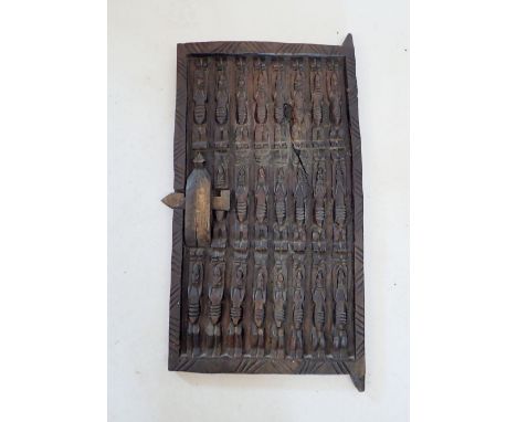 A carved Dogon tribal door, thought to be from a granary grain store in Mali, decorated three rows of figures, 62 x 35cm 