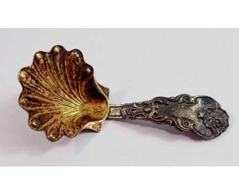 An Italian silver caddy spoon with gilt shell bowl and cast cupid and mask handle 