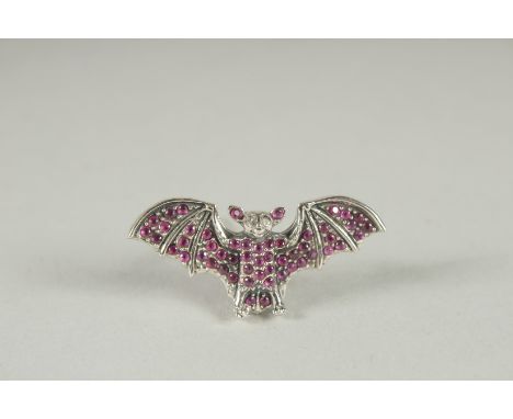 A SILVER RUBY, DIAMOND BAT BROOCH.