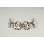 A pair of silver frog on a lily pad cufflinks in a box.