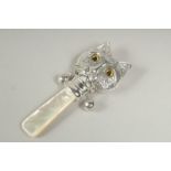 A silver and mother of pearl cat rattle.