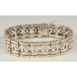 A silver pierced bracelet, in a heart shaped velvet box.